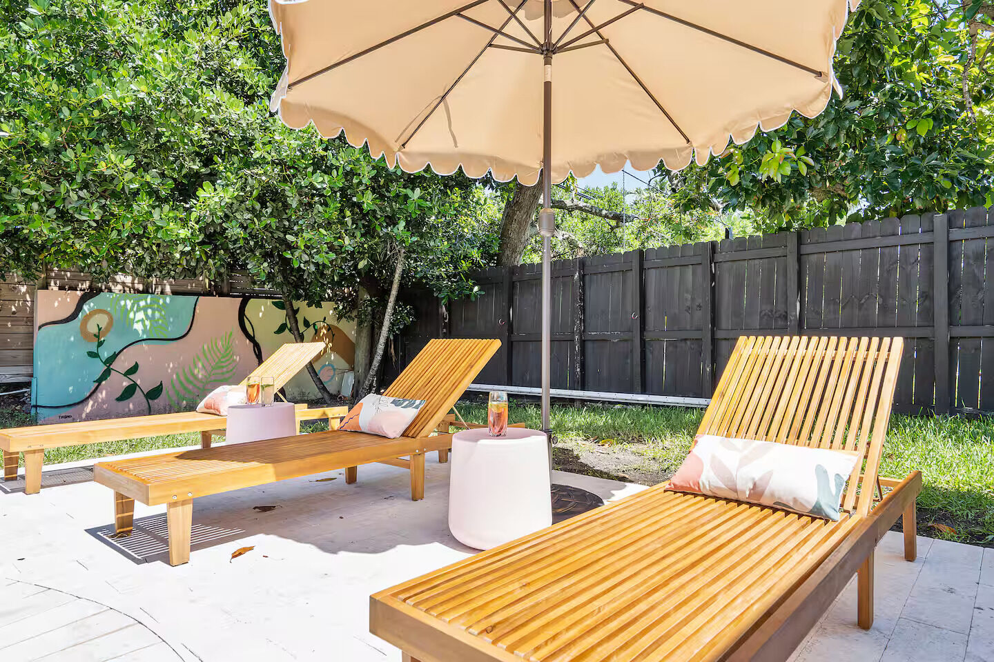 Lounge chairs under umbrella with mural background